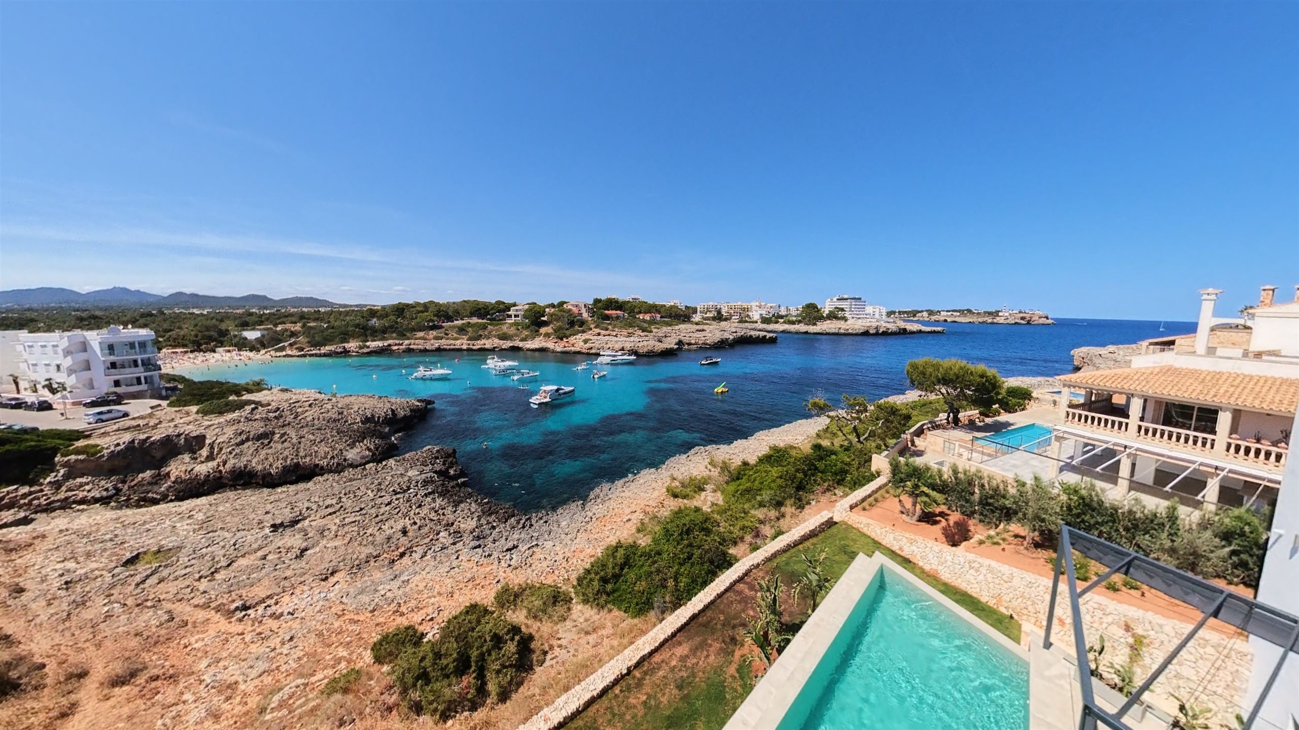 Luftaufnahme der Bucht von Porto Colom mit türkisem Wasser